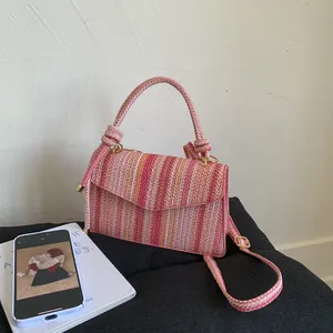 Detailed macro view of the colorful woven texture and golden hardware on the handbag