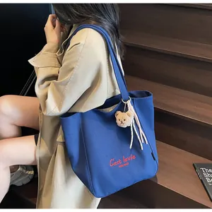 Navy canvas tote bag with red embroidery and a cute brown teddy bear charm detail