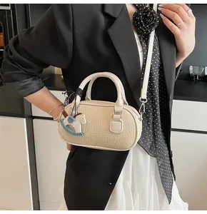 Detailed macro of beige lychee texture leather bowling bag with horse charm
