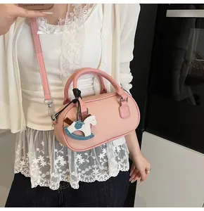 Pink pebbled leather bowling bag with a horse pendant charm and silver hardware