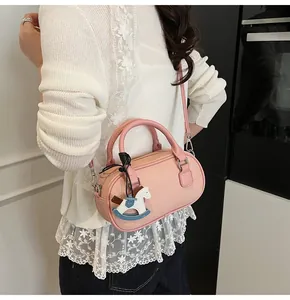 Pink lychee leather bowling bag featuring a cute rocking horse charm and slim shoulder strap