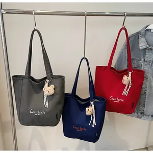 Trois sacs cabas en toile gris, bleu et rouge avec breloque ours et imprimé C'est lavie