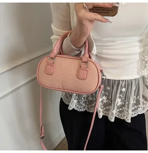 Detail of pink lychee textured leather bag with silver hardware and adjustable strap
