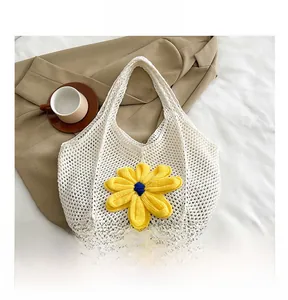 Detail of hand-woven white tote bag featuring a bright yellow crochet flower detail