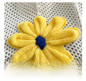 Close-up of yellow crochet flower detail on white woven hollow shoulder tote bag