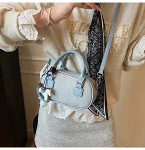 Detail of light blue litchi pattern mini bowling bag with scarf and horse charm