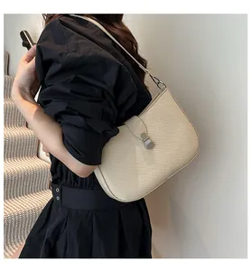 Detailed view of beige woven texture shoulder bag with elegant silver metal buckle on model