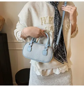 Detail of light blue pebble leather texture on a compact bowling bag with silver hardware