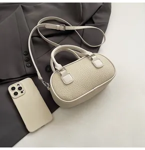 Top view of cream-white mini Boston bag with pebble leather texture and silver hardware