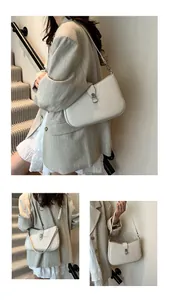 Detail of ivory woven leather shoulder bag with silver clasp and minimalist design