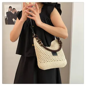 Détail du sac cabas beige tressé avec poignée en perles de bois et lanière
