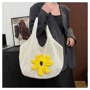 Detail of white hollow-out woven tote bag featuring a large yellow crochet flower accent