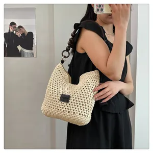 Détail du sac cabas en paille tissé main avec bandoulière en perles de bois brun