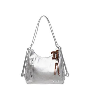 Sac à bandoulière argenté métallisé avec pampille et pendentif lettre sur fond blanc