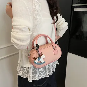 Pink lychee grain leather Boston bag with a cute rocking horse charm and top handles