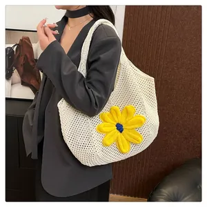 Detailed close-up of a white woven crochet tote bag with a 3D yellow daisy floral design