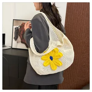Close-up of white crochet hobo bag with a large 3D yellow knit flower on a model