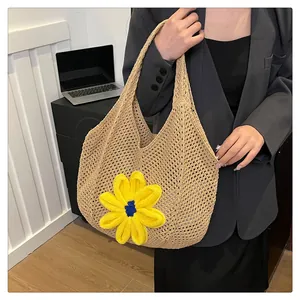 Detail of hand-woven tote bag with a large yellow sunflower and hollow mesh texture