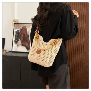 Détail du sac hobo tissé à la main avec perles en bois naturel et étiquette en cuir