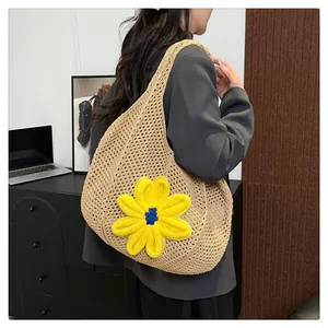 Detail of woven mesh texture and yellow crochet flower on the khaki summer tote bag