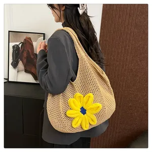 Detail of hand-woven beige tote bag with a large bright yellow knitted floral accent