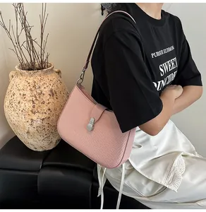 Detail of pink hobo bag with woven texture and silver buckle shown on a model