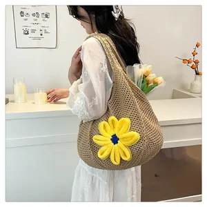 Detail of hand-woven straw tote bag with a large yellow crochet flower and tulip bouquet