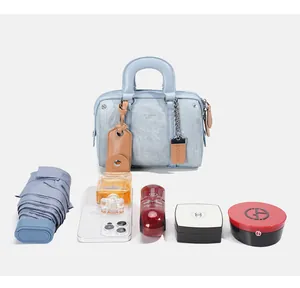 Light blue Boston bag showing storage capacity with umbrella, phone and cosmetics