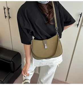 Detailed view of woven olive green handbag texture with silver metal snap closure