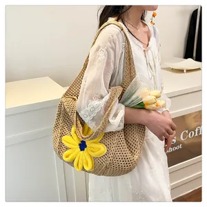 Detail of hand-woven beige tote bag with a yellow 3D floral decoration and mesh texture