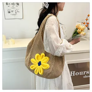 Detail of woven straw tote bag with large hollow mesh and yellow crochet flower decor
