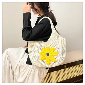 Detail of hand-woven crochet tote bag featuring 3D yellow flower and mesh knit texture