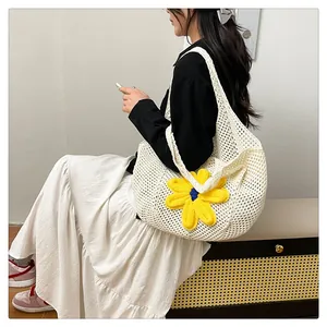 Close-up of beige crochet tote bag with large yellow flower charm for summer