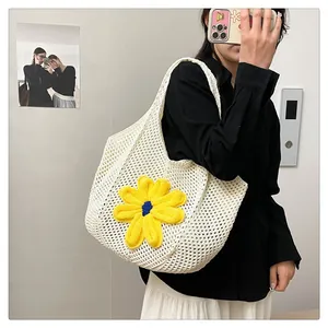 Detail of white hollow-out knit tote bag featuring a 3D yellow floral accent on the mesh
