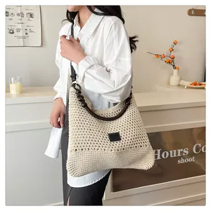 Detailopname van beige gehaakte draagtas met houten kralenhandvaten en gebreid patroon