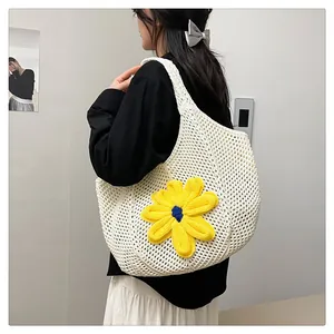 Detail of hand-crocheted hollow tote bag featuring a vibrant 3D yellow knit flower charm