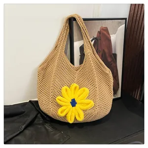 Detail of beige crochet tote bag featuring a 3D yellow knit flower and hollow weave