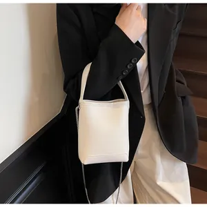 Off-white mini emmertas van generfd leer met zilveren ketting getoond op een model