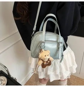 Borsa a tracolla azzurra con doppia cerniera e ciondolo a forma di orsetto di peluche