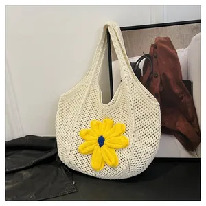 Detail of hollow knit tote bag with 3D yellow flower and intricate crochet texture