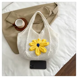 Close-up of white crochet tote bag with a large yellow knitted sunflower detail
