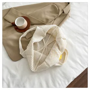 Detail of hand-woven cream hollow-out mesh tote bag on a casual lifestyle background