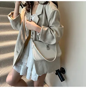 Detail of light beige woven crossbody bag featuring a classic metal turn-lock closure
