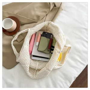 Detail showing the large capacity of a white hollow-out crochet woven tote bag