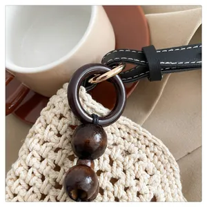 Détails du sac cabas en crochet crème avec perles en bois et bandoulière en cuir noir