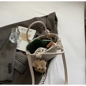 Internal view of cream woven bucket bag showing capacity for phone and lipstick