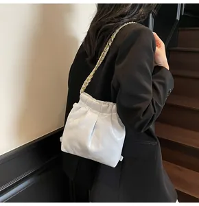 Detail of white quilted chain bag featuring glossy finish and elegant drawstrings