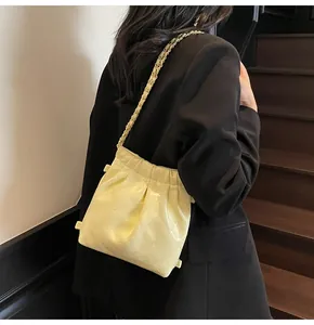 Close-up of yellow quilted chain bag featuring glossy finish and elegant texture