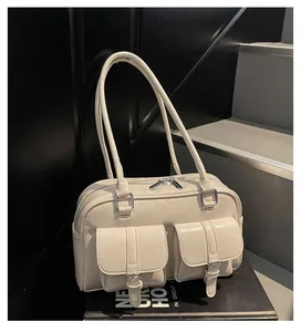Detailed macro view of beige faux leather tote bag showing front buckle pockets and texture