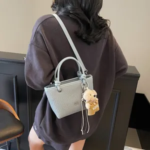 Light blue crossbody bucket bag with ripple texture and cute plush bear charm for women